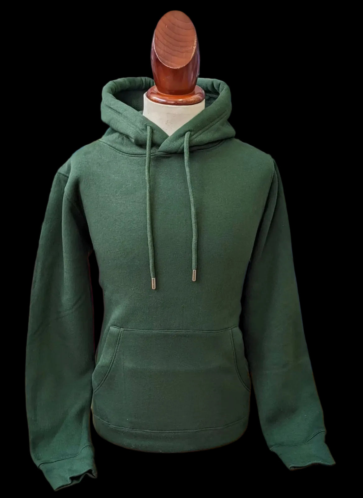 Green hoodie on a mannequin with a blurred background of folded clothes.