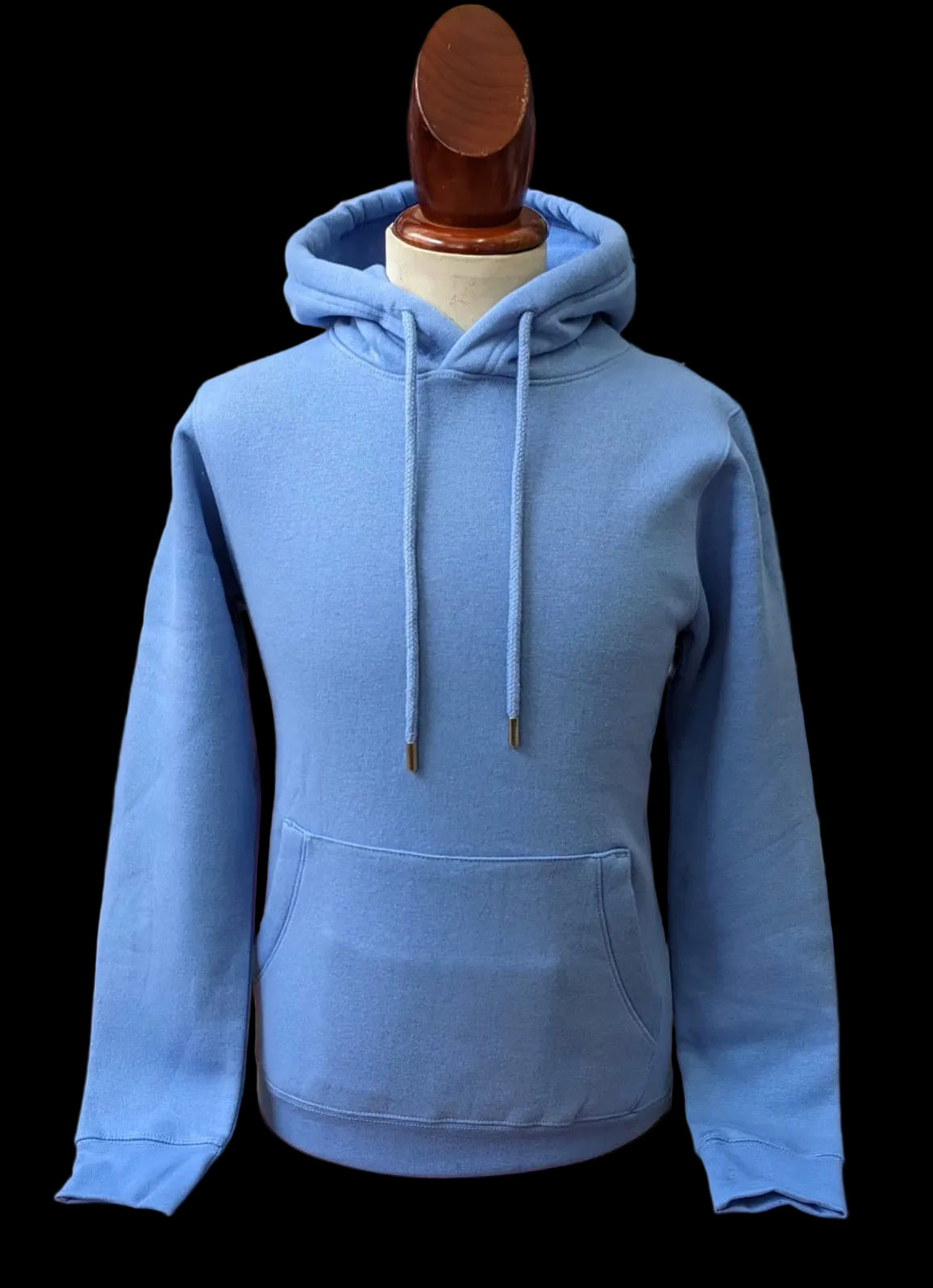 Blue hoodie on a mannequin against a blurred background of folded clothes.