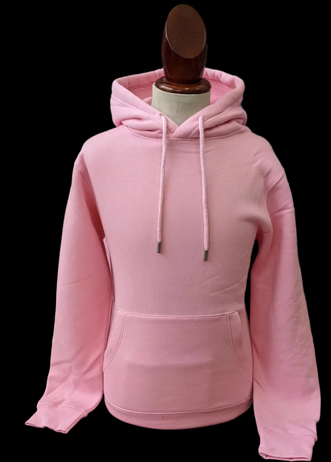 Pink hoodie on a mannequin with a blurred clothing store background